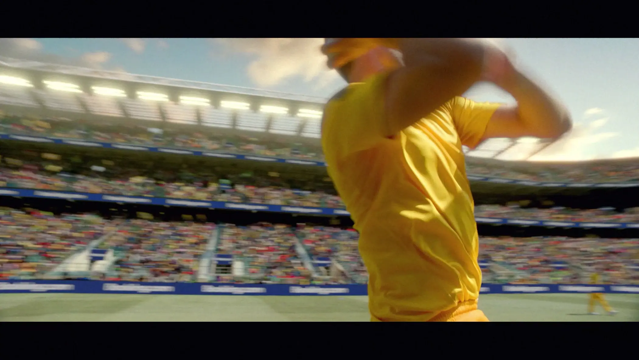 A man in a yellow shirt is swinging a bat. Description generated by AI